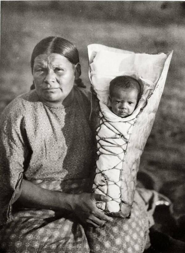 Moeder Comanche met baby in draagzak Comanche